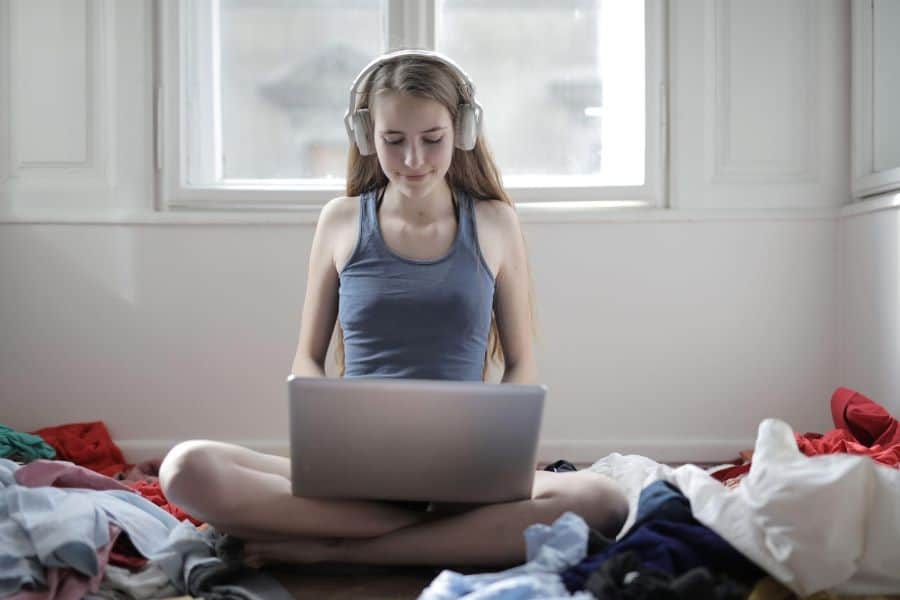 Download Old Podcast Episodes - How To Guide 1 Woman listening to podcasts while working on laptop on bed