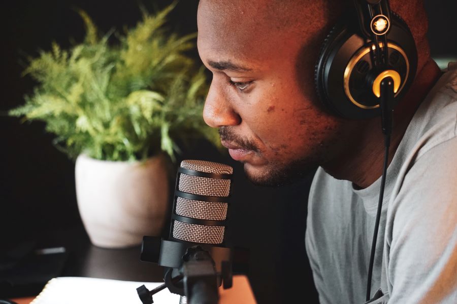 How Many Podcast Episodes Should You Launch With? 2 a man with a podcasting mic and headphone