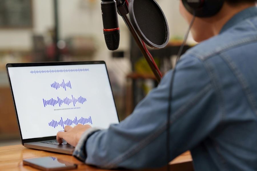 What Are Three Types Of Audio Editing Techniques? 1 podcaster recording in front of laptop